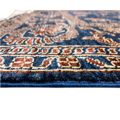 Close-up: blue carpet with red and gold ornaments, low-pile texture