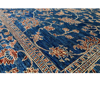 Close-up of the carpet surface: blue with gold and orange tendrils in a border pattern
