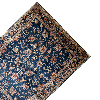 Ziegler carpet in corner view: blue base design with a gold floral vine and border
