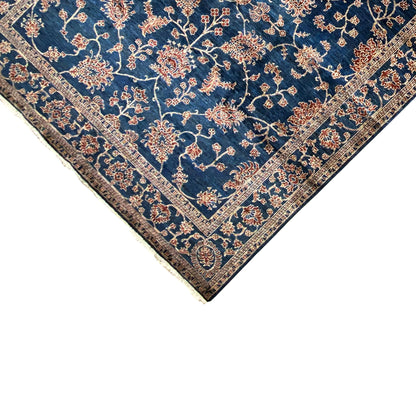 Detail view: blue carpet with an ornamental border pattern and visible pile edge