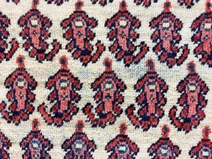 Close-up of carpet pattern: repeating medallions in red, dark blue, and cream