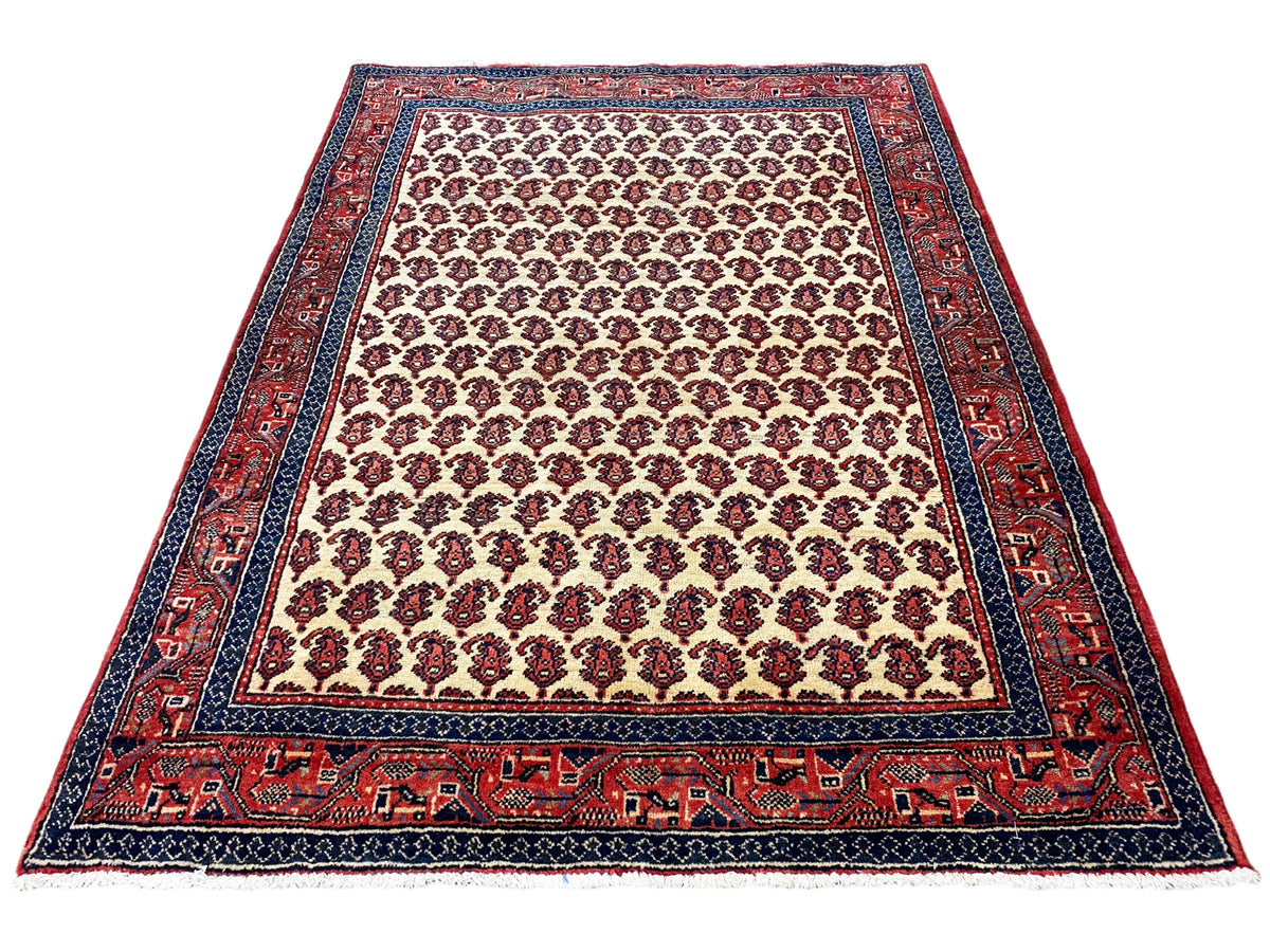 Rug with a rug border and patterned frieze; cream background with red and blue accents