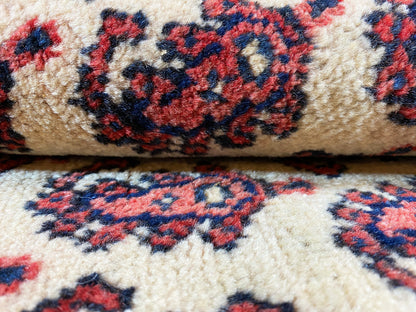 Close-up: knotted pile in cream with a dense floral and ornamental pattern