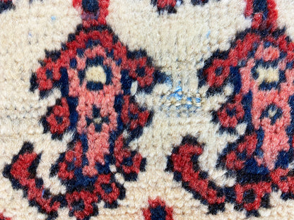 Small patterned detail: floral motif in red and dark blue on a light background