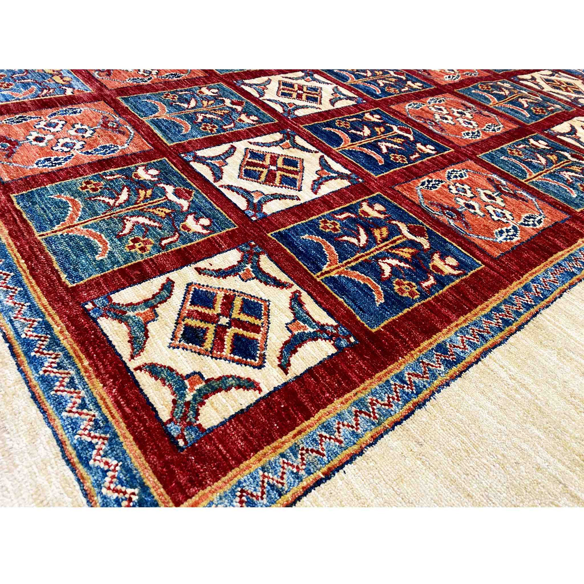 Close-up of the carpet pattern: blue and red tiles with delicate cream-colored ornaments