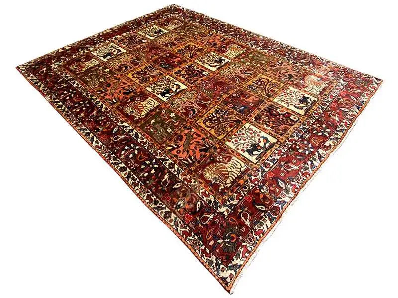 Oriental rug laid flat with patchwork patterns in red, orange, and beige