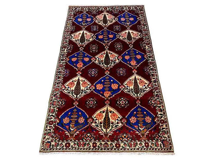 Rectangular Bakhtiari rug, burgundy with blue and cream-colored diamonds and a border.