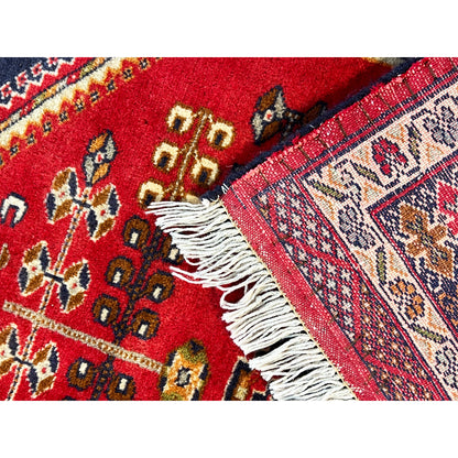 Baluch rug with a red geometric pattern and white fringes