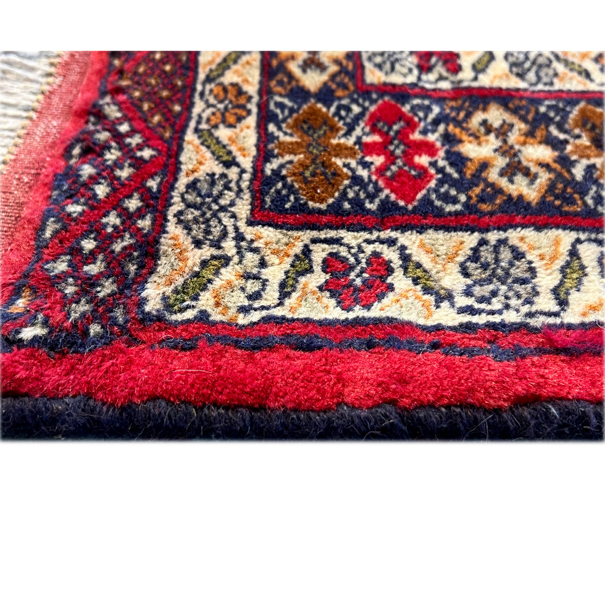 Baluch rug close-up of the lower edge with fringes and a red border
