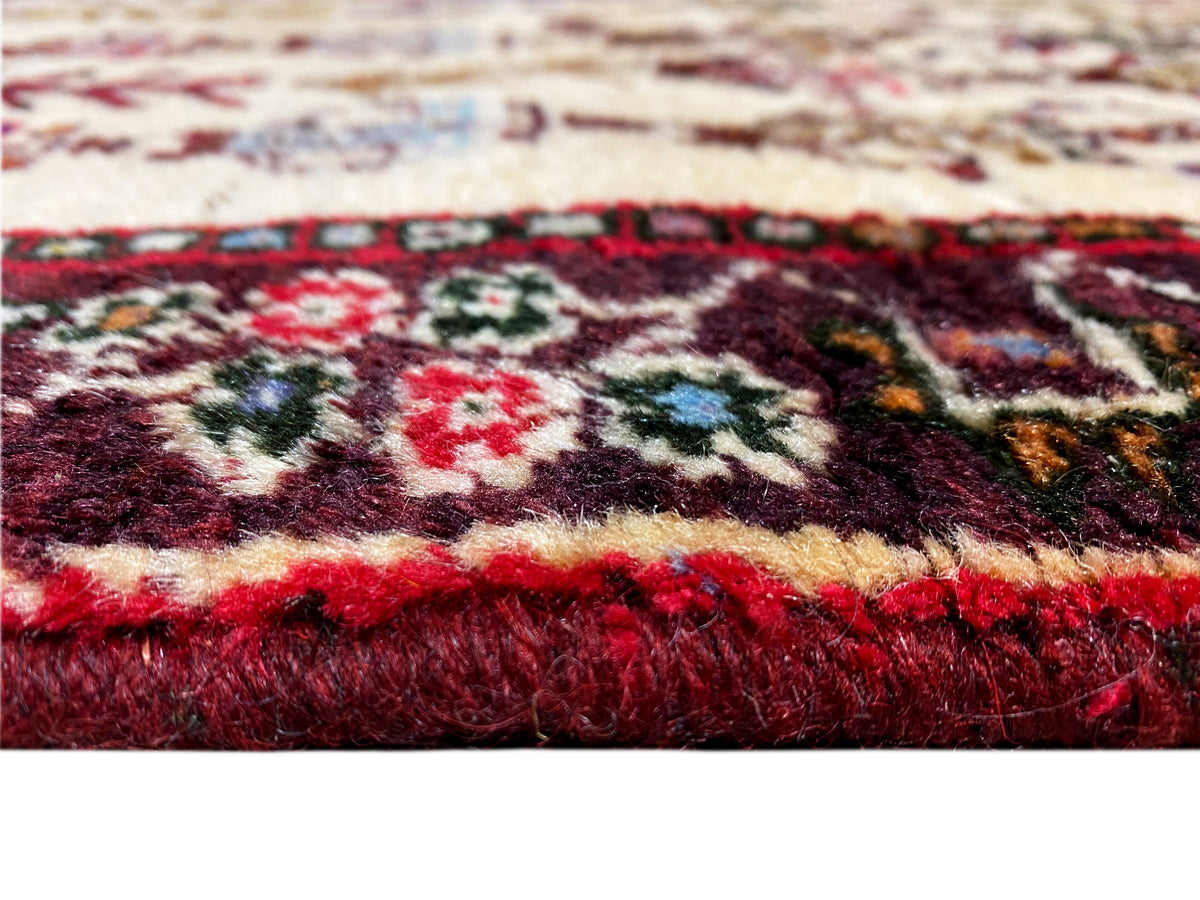 Close-up of a Baluch rug: thick pile with red and multicolored patterns along the edge