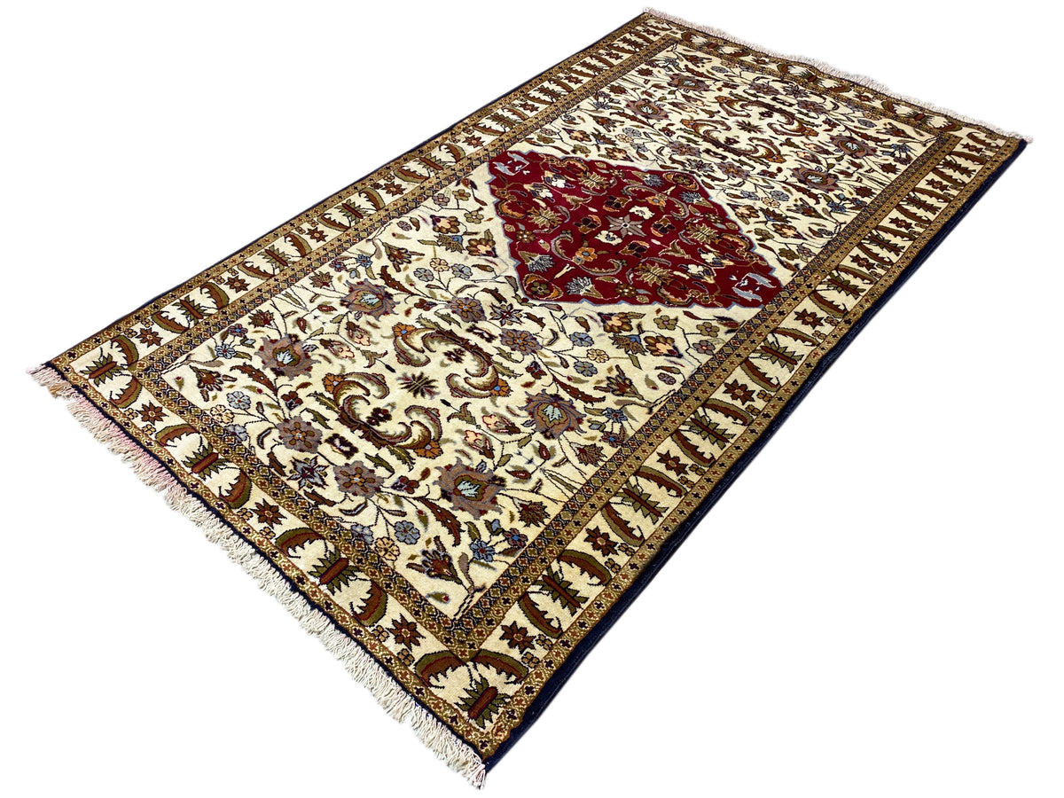 Baluchi rug, spread diagonally, cream-colored with a red medallion and border