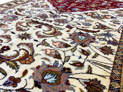 Baluchi carpet close-up: colorful ornaments on a cream-colored background