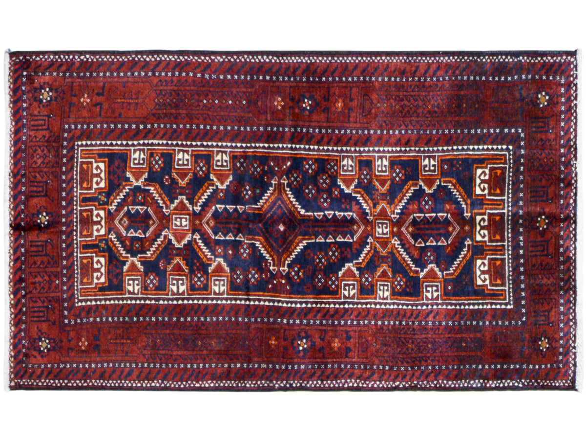 Rectangular Baluchi rug, red and blue, with a central ornamental field and an encircling border.