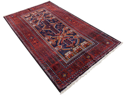 Rectangular Baluchi rug, red with a dense ornamental field in blue/white and a surrounding border.