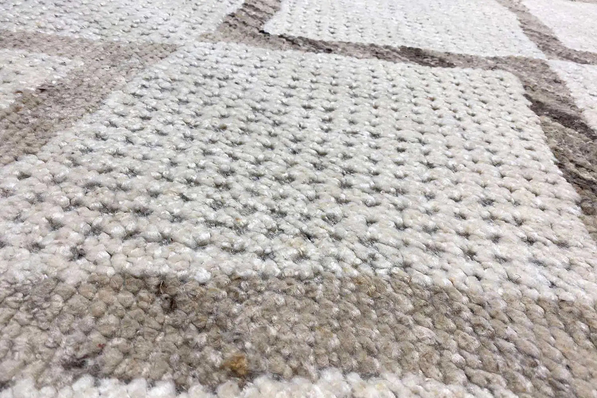 Berber rug with a multicolored woven pattern and dense, light-beige pile