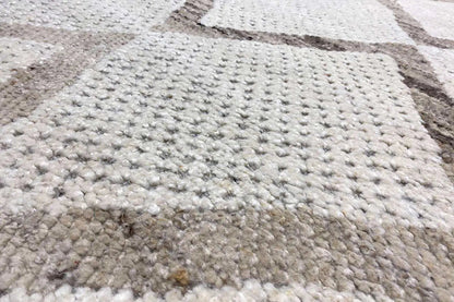 Berber rug with a multicolored woven pattern and dense, light-beige pile
