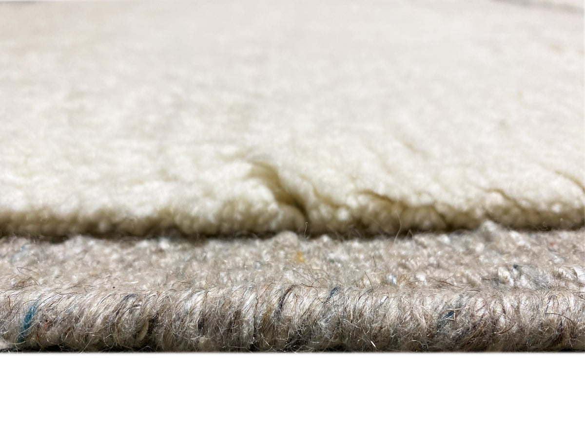 Berber-Teppich Detail der Florhöhe: weiche creme und graue Fasern, glatte Kante