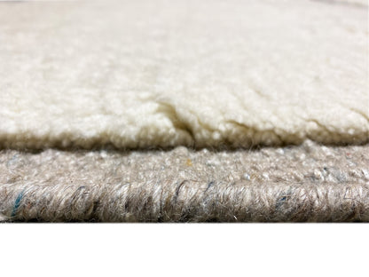 Berber-Teppich Detail der Florhöhe: weiche creme und graue Fasern, glatte Kante