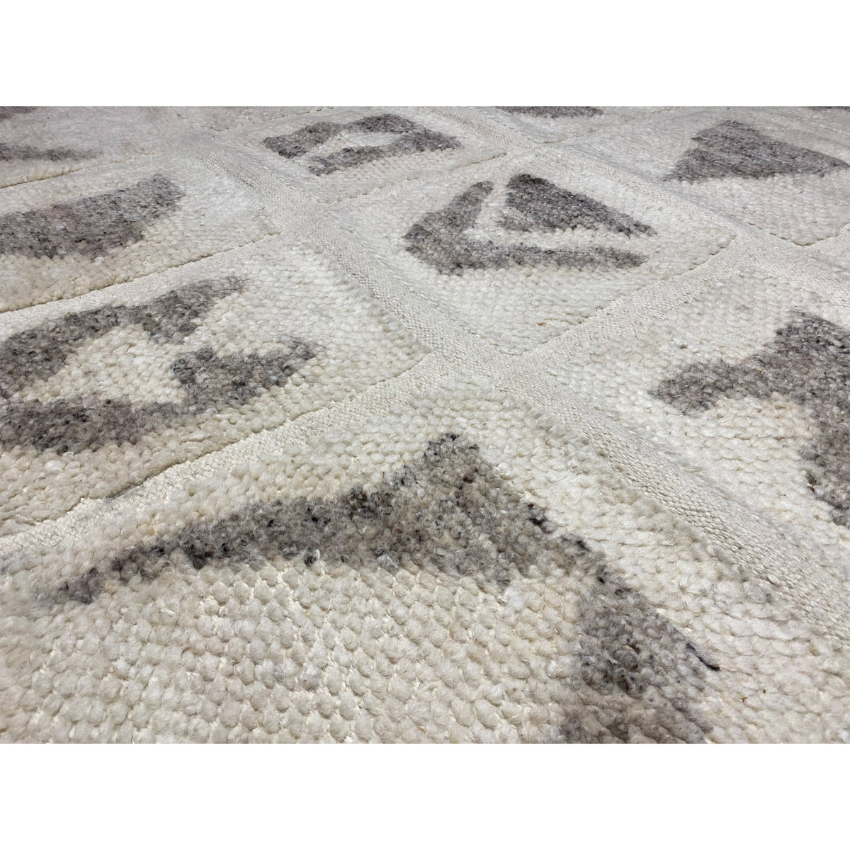 Close-up: Berber rug with beige pile and gray patterns in a block grid pattern
