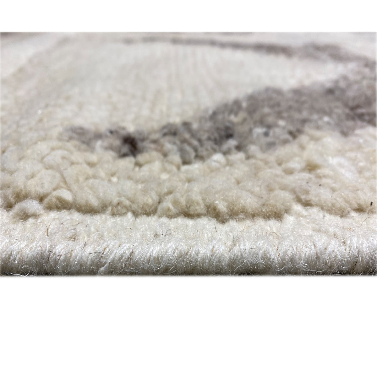 Close-up of the carpet surface: beige pile with gray areas and a soft texture