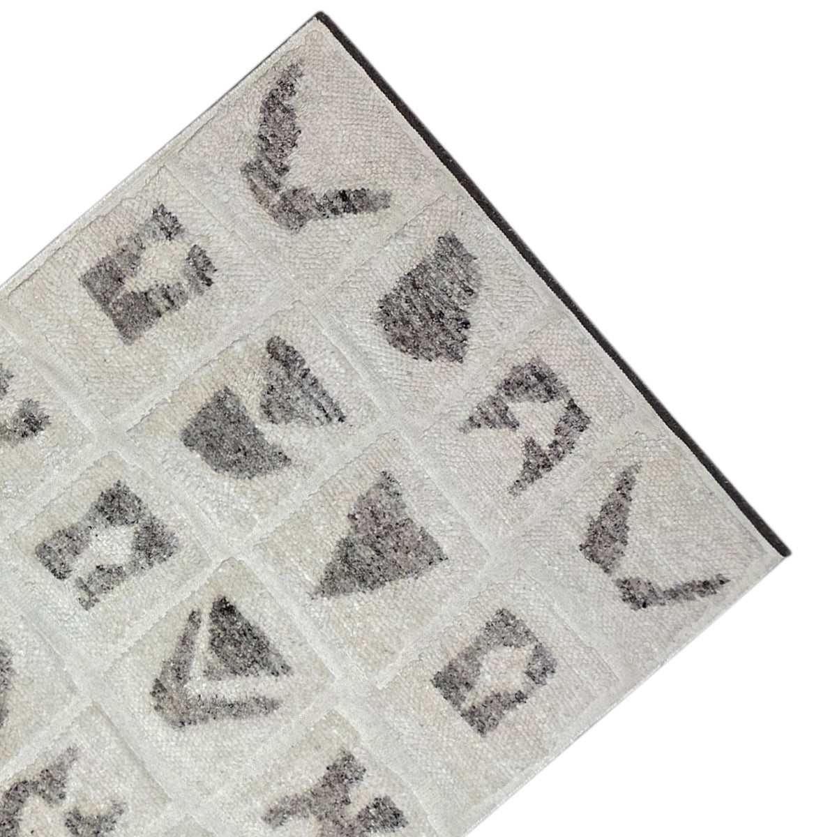 Detailed view of the edge: Berber rug with a beige background and gray motif panels