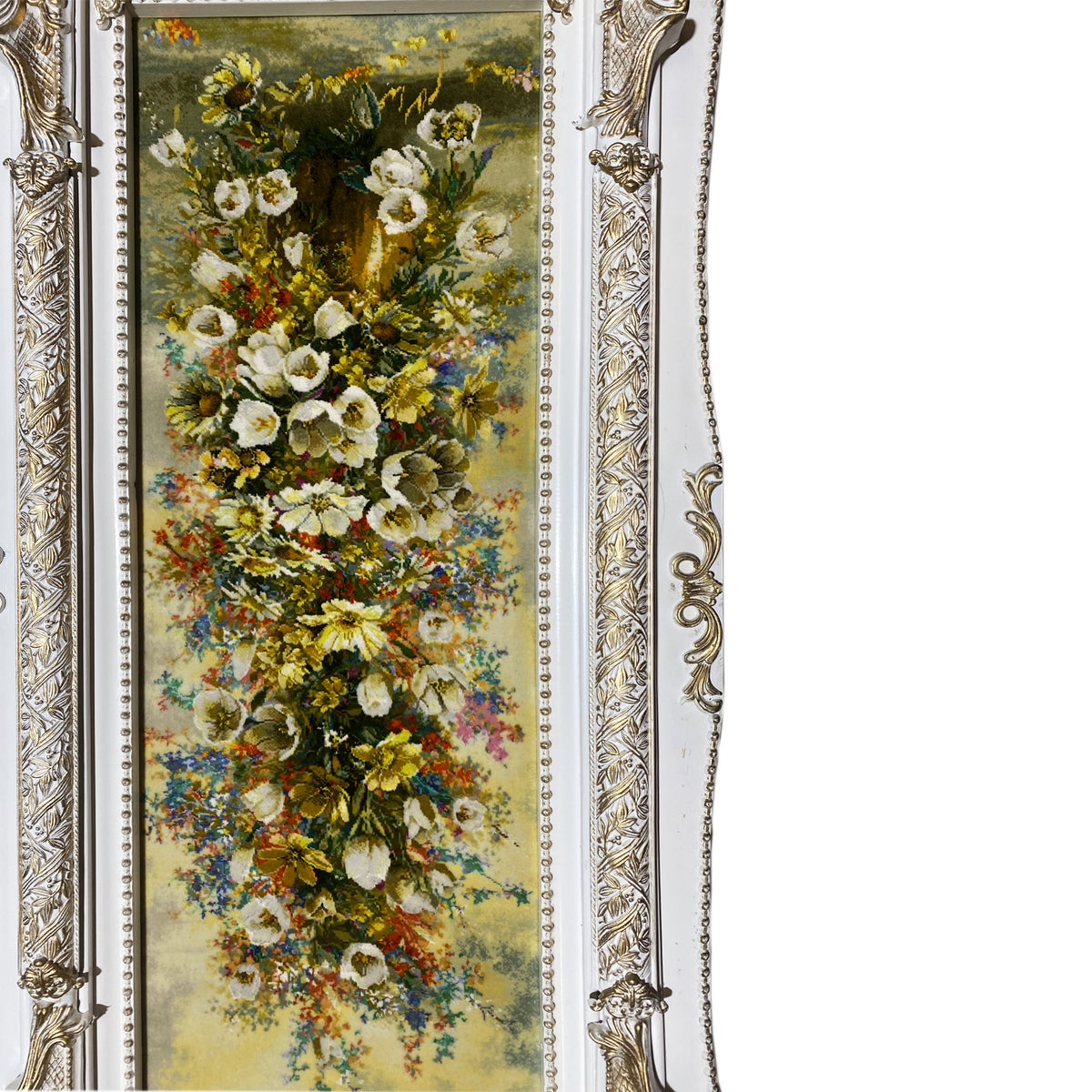 Floral tapestry in a silver-and-gold ornate frame, close-up.