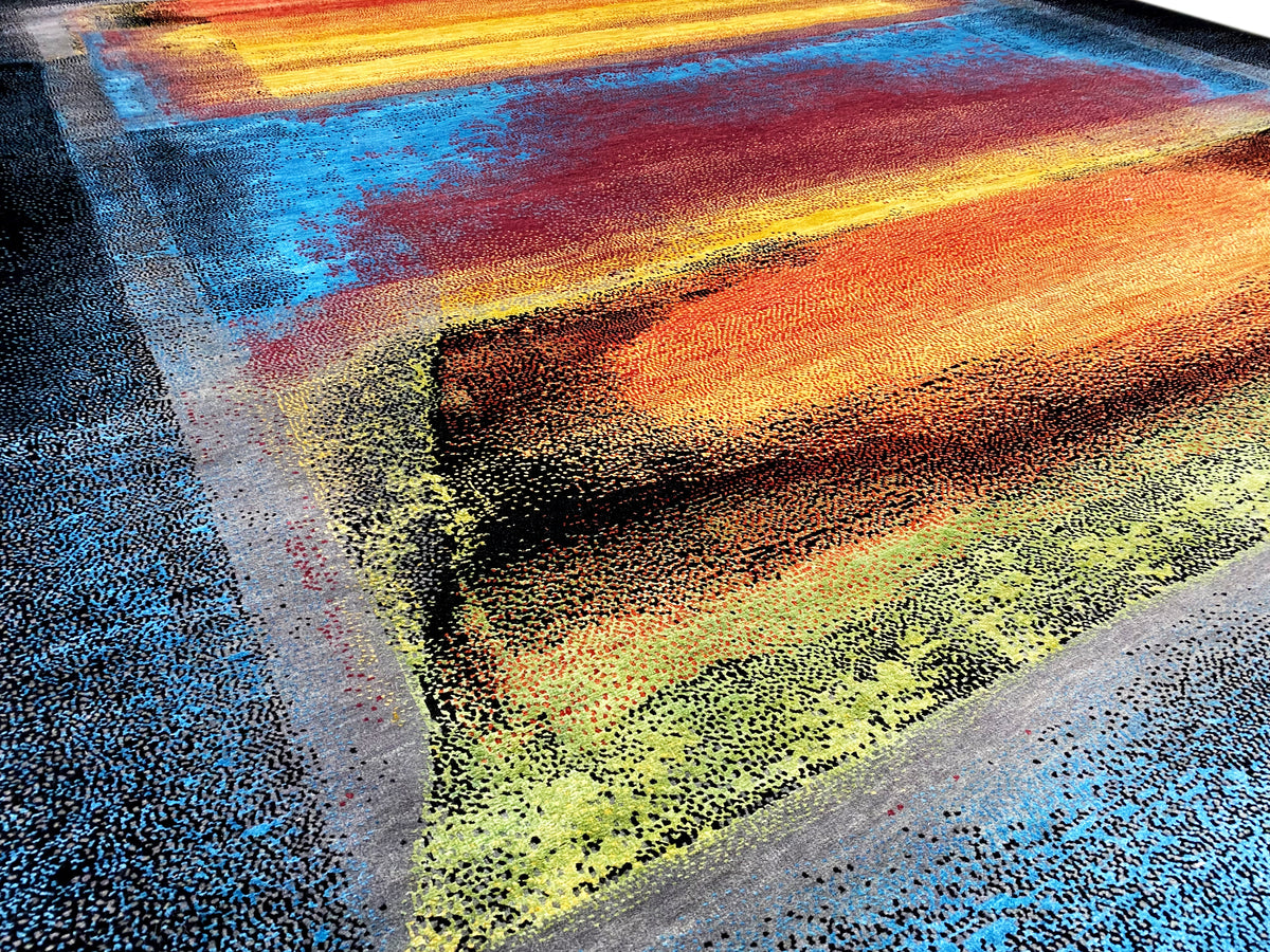 Close-up of the rug with an abstract banded pattern in blue, orange, yellow, and green