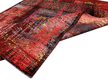 Designer-Teppich, rechteckig, rötliche Musterflächen mit bunten Linien, gefaltete Liegeansicht