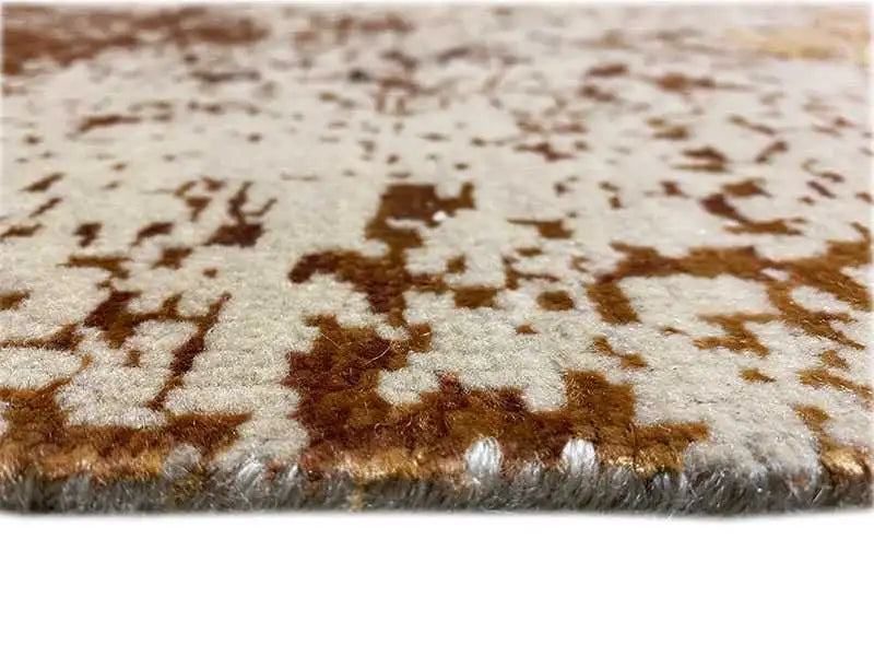 Designer rug close-up: brown-and-white pattern with visible pile texture along the edge