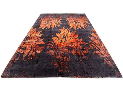 Rectangular designer rug with a dark pile and orange ornamental pattern, top view.