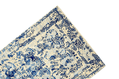 Carpet corner with a blue decorative border and floral ornamental pattern on a beige background