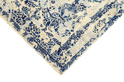 Carpet corner in detail: dense blue floral ornament on a beige background, border