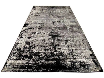 Rectangular rug with an abstract black-white-gray design on a light background