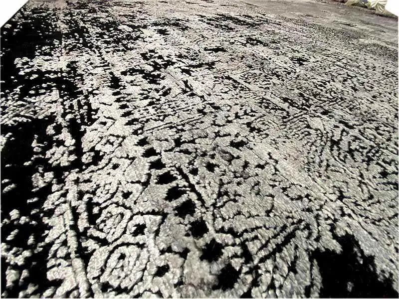 Large-area carpet surface: abstract black-and-white-gray pattern with a swirling effect
