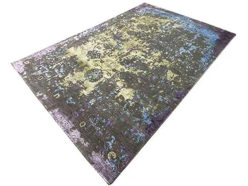 Designer rug at an angle: yellow-green background with blue-violet splashes of color