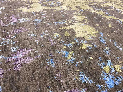 Close-up of a designer rug: purple, blue, and cream-colored ornaments on a dark background