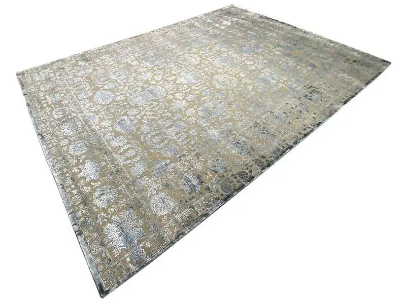 Designer rug positioned at an angle, cream/beige surface with blue-gray patterned elements