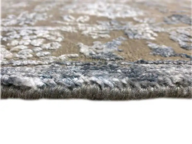 Designer rug close-up: pile with blue-gray contrasting areas and cream textures