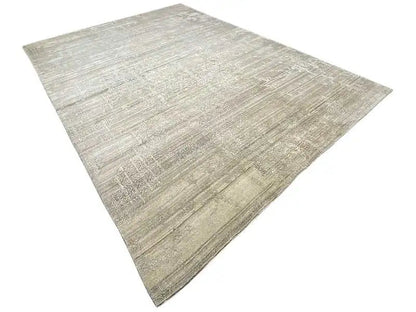 Rug at an angle with a beige-gray, textured woven look