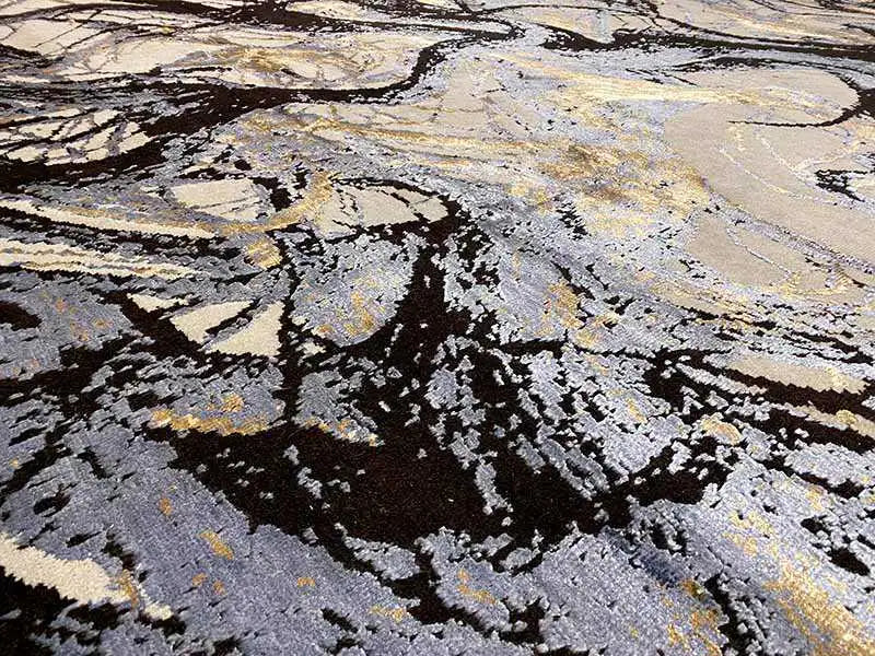Designer rug close-up: black lines, gray and beige areas, textured pile