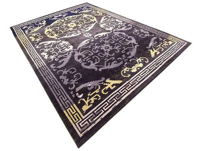Rug with a dark blue-gray pattern, white ornamentation, and gold-colored details; decorative border.