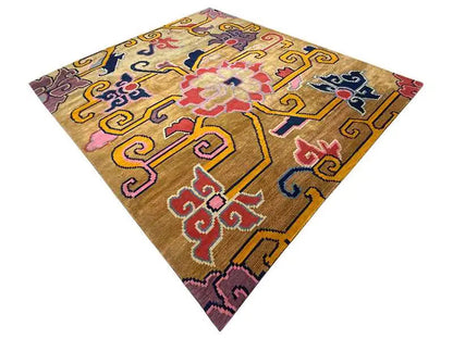 Square designer rug with a yellow-brown base and multicolored ornamental pattern