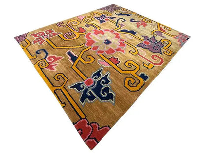 Square designer rug with a golden-brown base and a colorful diamond and cross pattern
