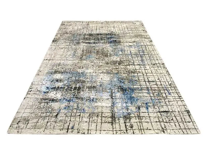 Rug with an abstract grid and faded blue pattern elements, laid flat