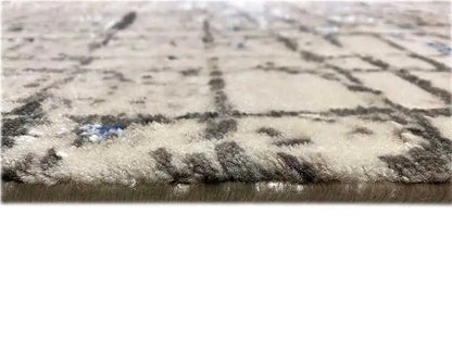 Rug edge with a fringed look and abstract pattern, beige-gray pile with blue areas