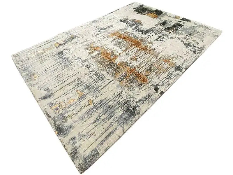 Designer rug in a triangular cutout: light gray texture with black and ochre-colored spots
