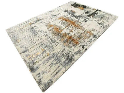 Designer rug in a triangular cutout: light gray texture with black and ochre-colored spots
