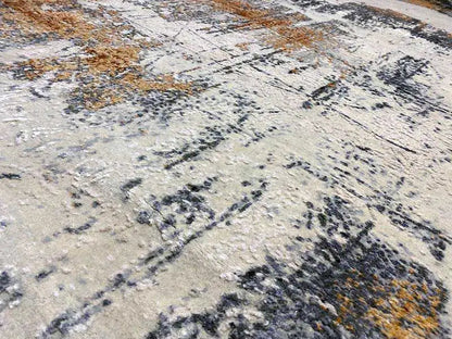Designer rug, detail view: abstract color blocks in light gray, black, and ochre