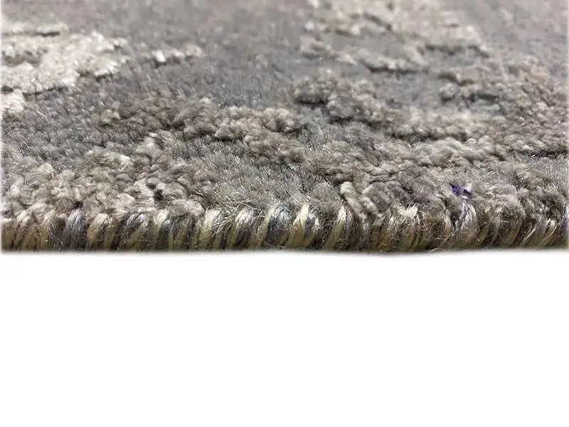 Gray marled carpet pile in detail with a subtle sheen and bound edge