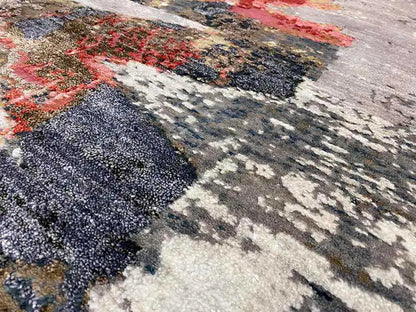 Carpet surface with a coarse, fluffy pile and contrasting brushstrokes in blue, red, and gray